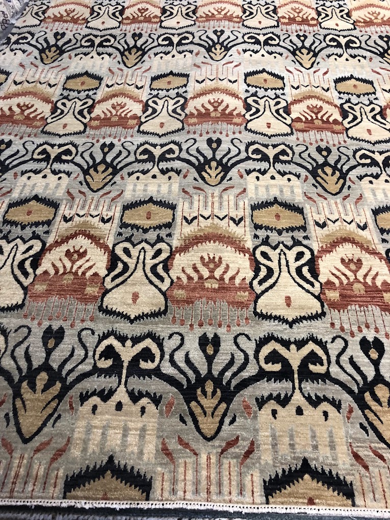 Ornamental rug with repeating black, ivory, and rust motifs